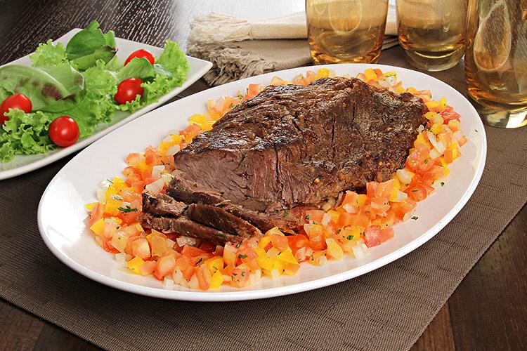 Aprenda essa deliciosa receita de fraldinha assada. Ela é temperada com suco de abacaxi. Aprenda a fazer um vinagrete saboroso para acompanhar.