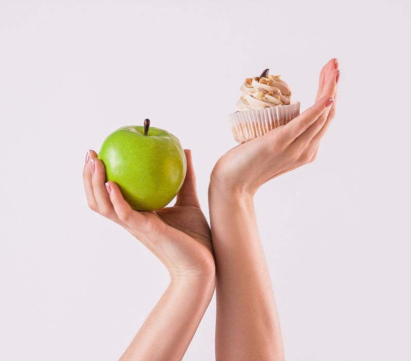 Pessoa escolhendo fruta ou doce na dieta