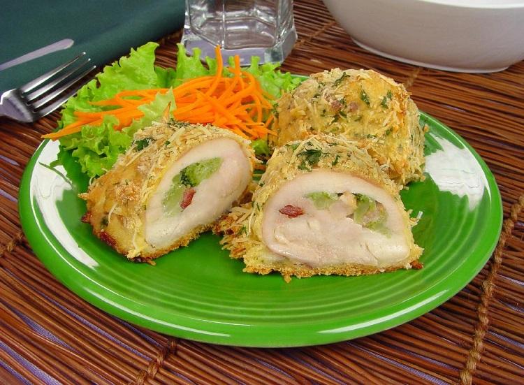 receita de sobrecoxa desossada gratinada com queijo parmesão e ervas, recheada com brócolis, acompanhada de salada de alface e cenoura ralada.