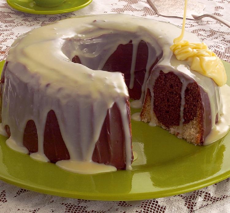 Receita de bolo caseiro mesclado, leite condensado em cima, prato verde