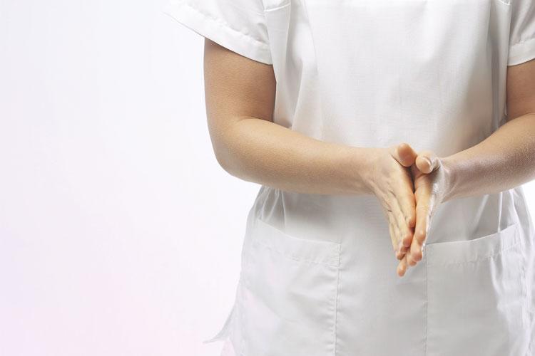 Mulher vestida de branco com as mãos fechadas