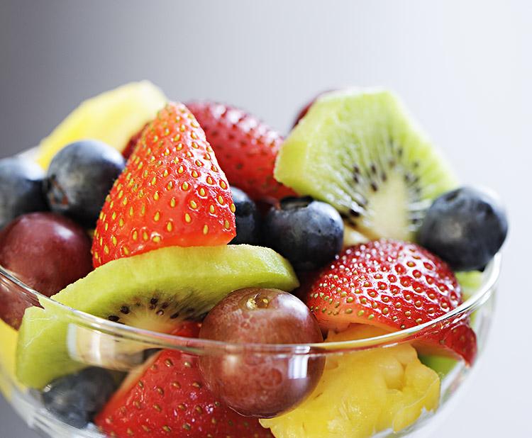 Potinho com diversas frutas - uva, kiwi, morango e manga.