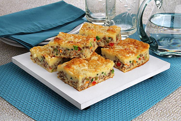 Pedaços de torta empilhados em um prato de servir branco.