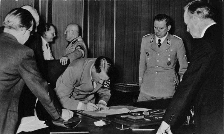 hiler assinando um tratado que von ribbentrop conseguiu entre os paises vizinhos