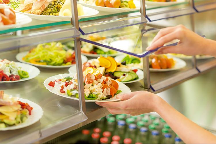 mulher pegando comida no self-service