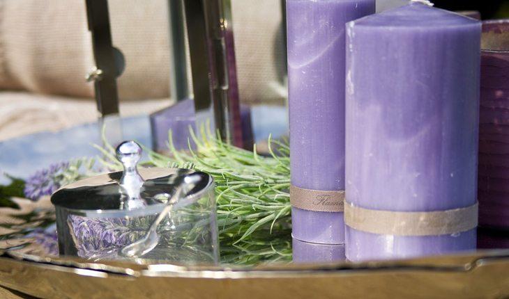 duas velas grossas na cor violeta sobre uma mesa de madeira