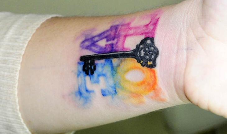 tatuagem aquarela de chave no meio e ao redor a palavra love