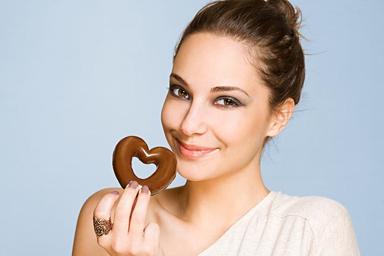 mulher comendo doce, sorrindo, morena , cabelo preso