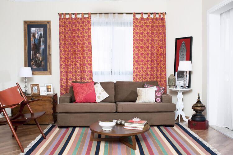 Sala aconchegante com cortinha, sofá, abajur, quadro
