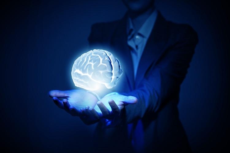 maos-segurando-cerebro-humano-iluminado