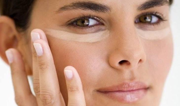 Mulher com corretivo para olheiras embaixo do olhos