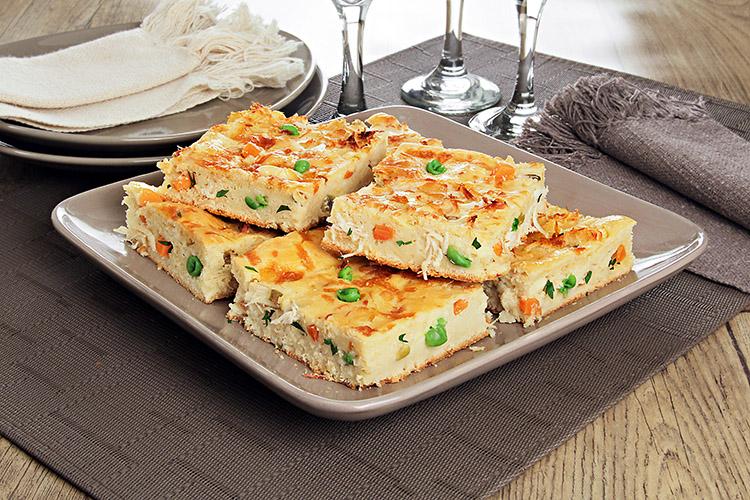 Pedaços de torta de frango e legumes empilhados em um prato.