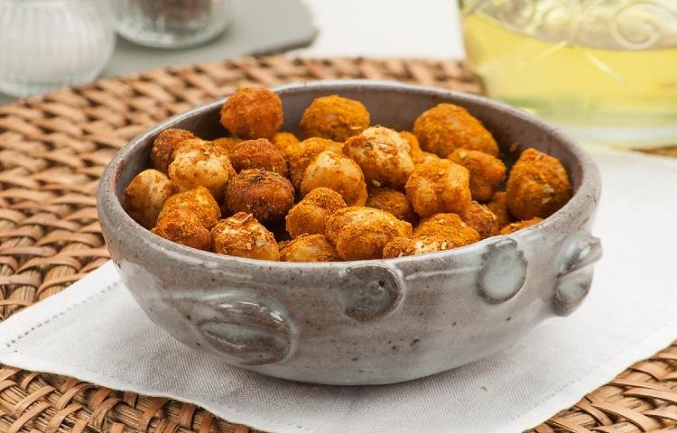 Grão de bico crocante de coloração laranja dentro de uma travessa de metal