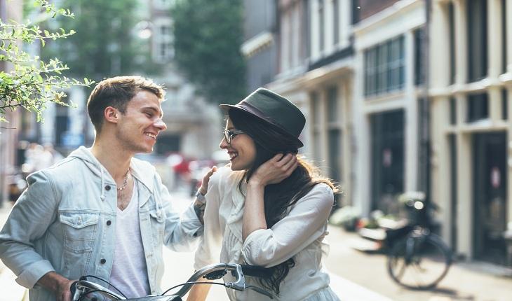 Casal sorrindo na rua, homem na bicicleta