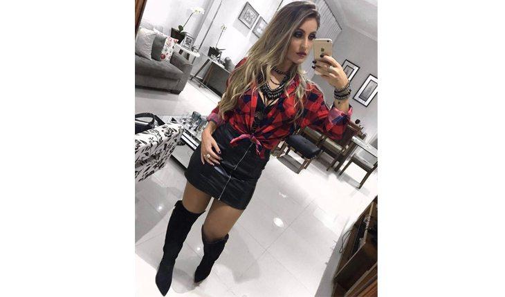 mulher com bota over the knee, saia preta e blusa xadrez