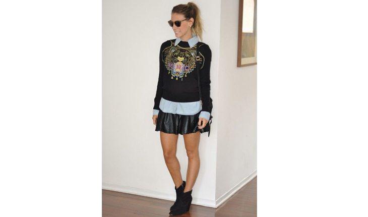 mulher com saia, camisa jeans e blusa estilo moletom por cima e coturno preto