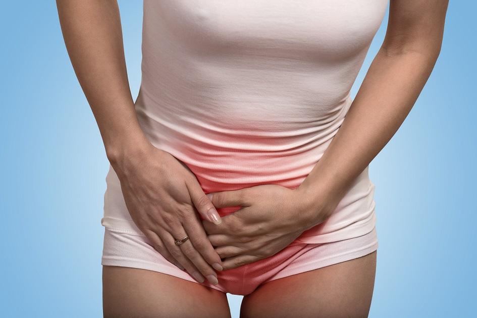mulher com a mão na barriga sentindo dor de cólica menstrual.