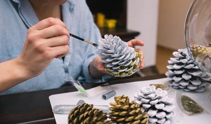 Foto de mulher decorando pinhas