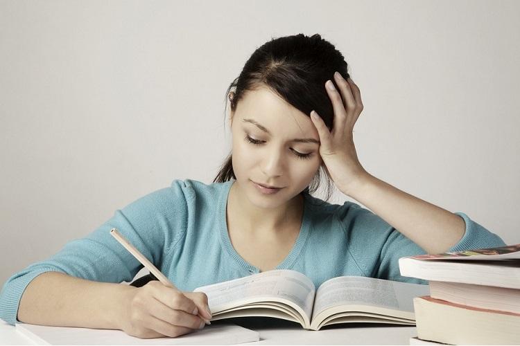 Menina com lápis na mão estudando o hífen