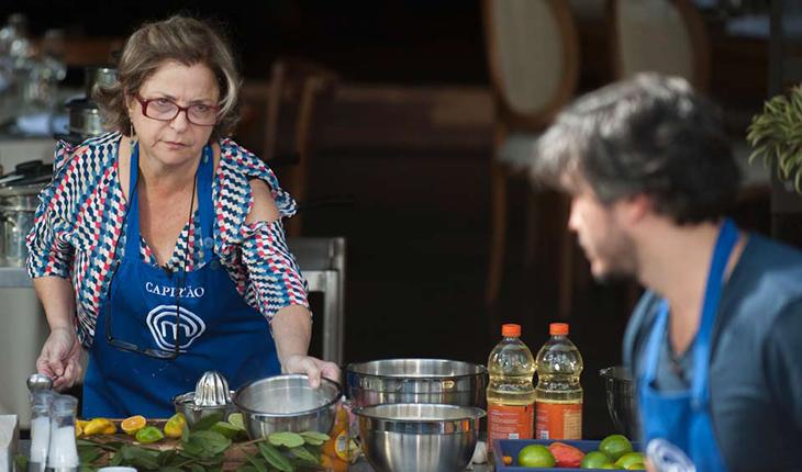 Na prova em equipes a céu aberto, Mirian observa Fabrízio de longe enquanto pega um dos potes da bancada da cozinha