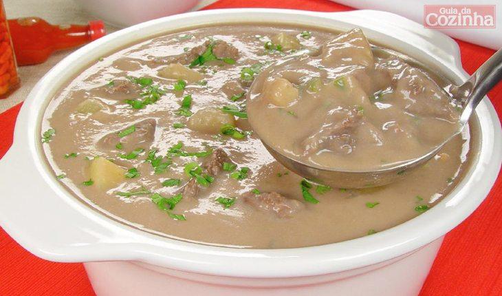 Foto da receita de caldo de feijão cremoso em uma cumbuca redonda.. A foto compõe uma galeria sobre os benefícios do feijão.