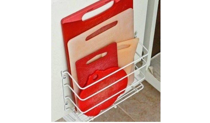 A foto mostra um suporte para colocar na porta do armário que serve para guardar tábuas de corte, tantas e suportes.