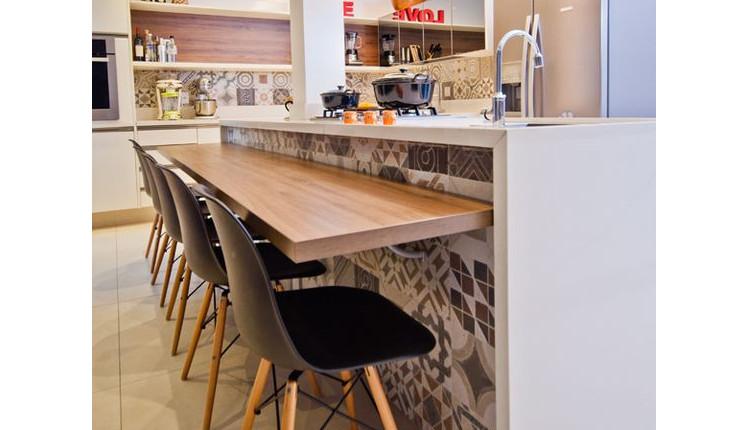 A foto mostra uma bancada de comida que fica agregada à bancada da cozinha, criando uma mesa.