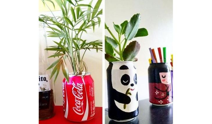 Na foto há duas imagens que mostram latinhas de alumínio sendo utilizadas como vasinhos. Na primeira imagem a latinha é de Coca-Cola e na segunda a latinha está pintada com o desenho de um panda. Atrás desta há outra latinha sendo utilizada para guardar lápis e canetas que está pintada com o desenho de uma gueixa.