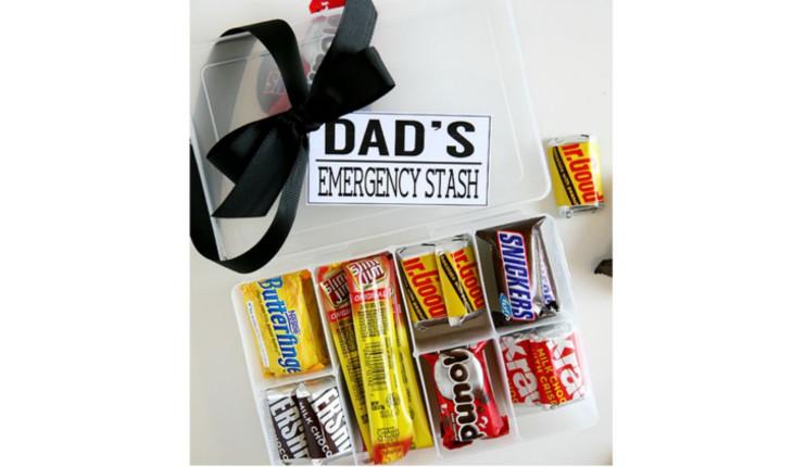 Na foto há uma caixa de plástico com divisórias e em cada divisória há alguns tipos de chocolate. Na parte de cima da caixa está escrito 