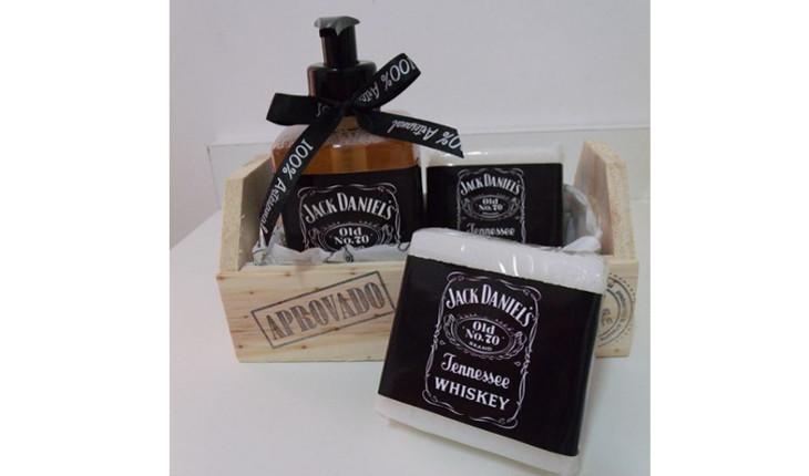 Na foto há uma caixinha de madeira com produtos de higiene masculina que estão com uma etiqueta personalizada com a marca de wiskhy.