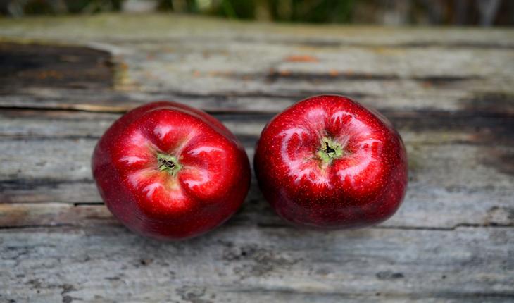 2 maçãs sobre uma superfície de madeira