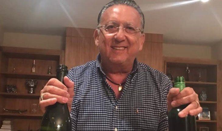 Quanto ganha o Faustão. Na foto, está Galvão Bueno segurando duas garrafas de vinho