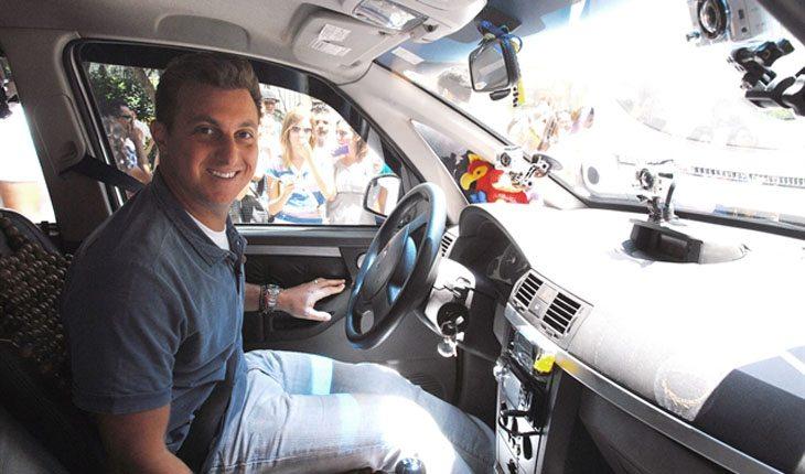 Quanto ganha o Faustão. Na foto, está Luciano Huck dentro de um carro