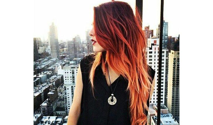 mulher ruiva com ombré hair e pontas do cabelo laranja