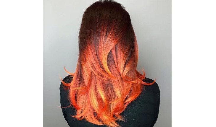 mulher ruiva com ombré hair e pontas dos cabelos alaranjadas