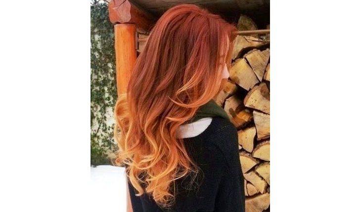mulher ruiva com ombré hair com as pontas dos cabelos alaranjas