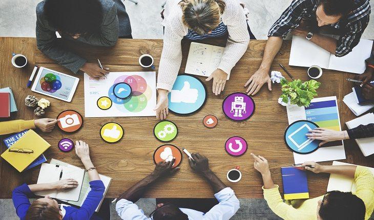 foto aérea de uma mesa de trabalho com várias pessoas à volta