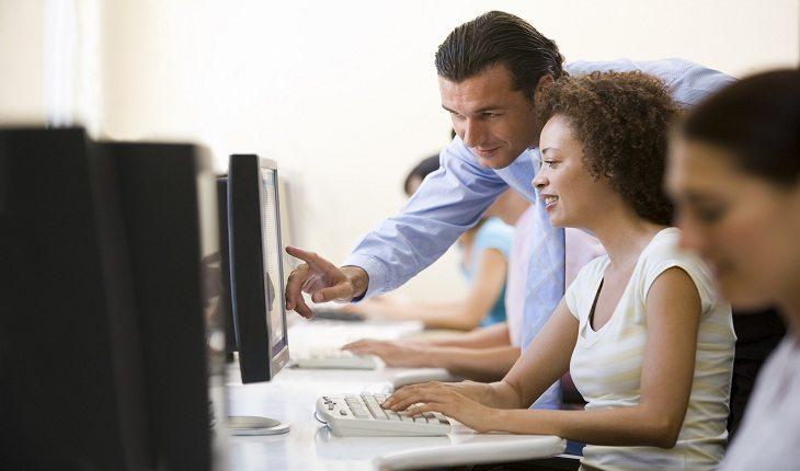 foto de um homem ensinando uma mulher dentro de um ambiente de trabalho