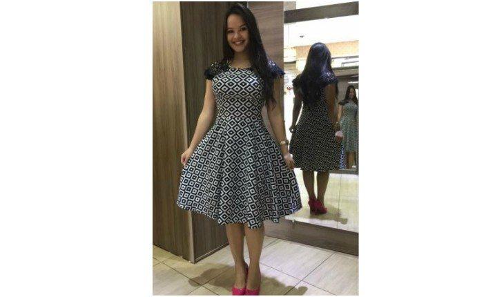 Mulher usando vestido evasê de estampas geométricas.