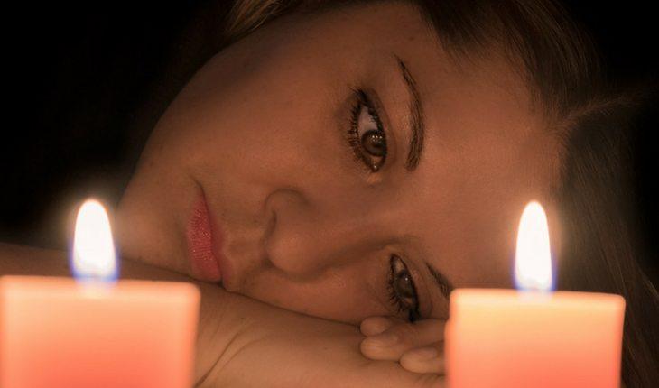 Mulher olhando para velas acesas